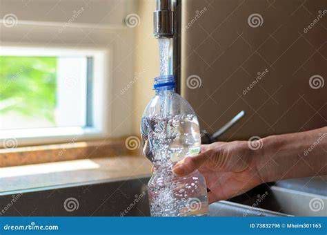Persona che riempie una bottiglia di plastica usa e getta
