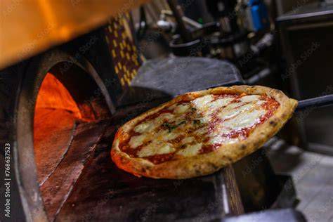 pizza appena sfornata da un forno a legna