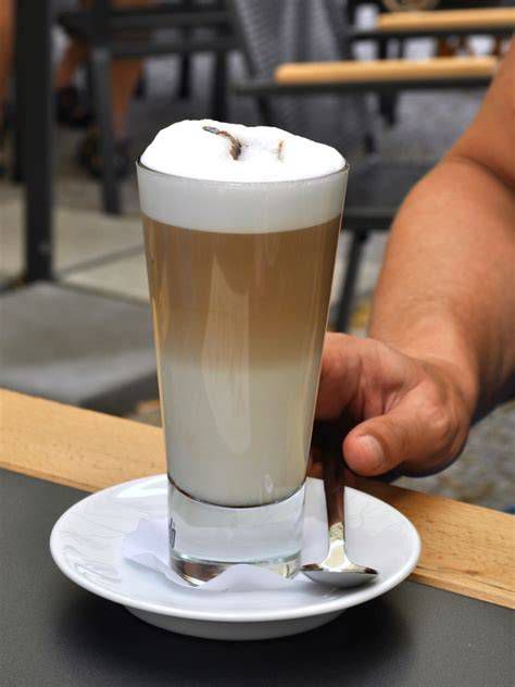 Un bicchiere alto di latte macchiato con le sue caratteristiche sfumature