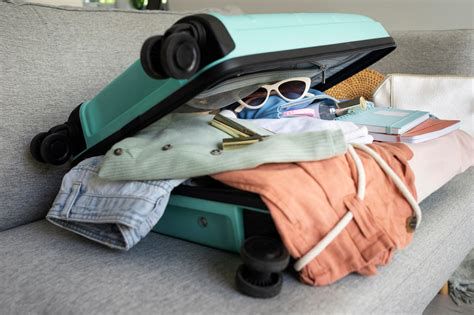 Valigia con vestiti arrotolati e stiratrice verticale da viaggio